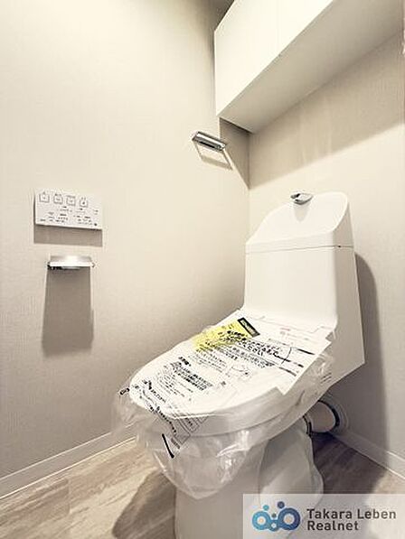 ウォシュレット機能付きのトイレは壁掛けリモコンの上位グレードを採用。便座がスッキリした印象となり、限られた空間を広く見せる効果があります。