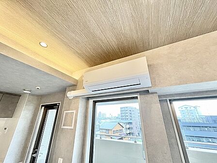 素材感のあるクロスと木目調の天井が調和する、落ち着いたインテリア空間