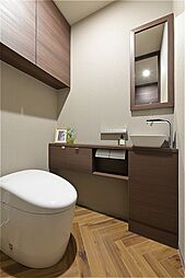 温水洗浄便座付きのトイレ。独立した手洗いカウンターを設けています。トイレは玄関近くに配置しているため、お出かけ前や帰宅時にも気軽に使用できる設計です。