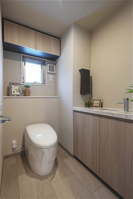 窓からやわらかな明るさが広がり、落ち着いた雰囲気のトイレです。独立した手洗い器があり、いつでも清潔に使えます。