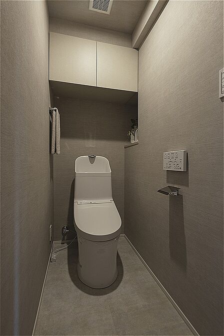 清潔感のあるトイレです。温水洗浄便座付きで、毎日快適に使うことができます。掃除用具やトイレットペーパーのストック置きに便利な吊戸棚付き。