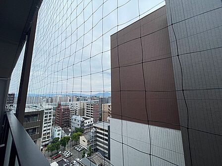 高層階からの眺望。都市の活気を感じながら、遠くの山々も望める開放的な景色です。