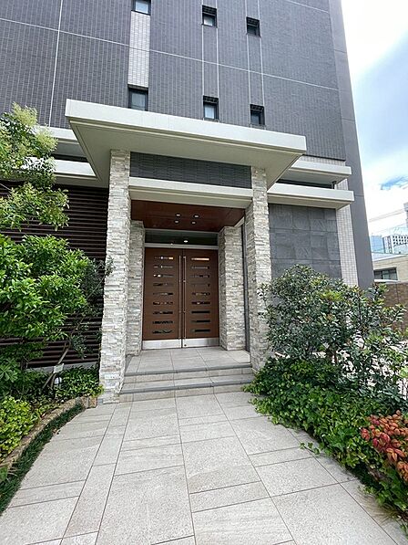 洗練された外観デザインが印象的なエントランス。植栽の緑が都会的な住まいに彩りを添えます。