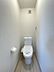 トイレ：清潔感のある明るいトイレ空間。換気扇も備え、快適にお使いいただけます。木目調の床材が優しい印象を与えます。