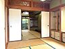 その他：趣のある和室は、落ち着いた佇まい。庭の緑が窓越しに広がり、季節の移ろいを感じられます。伝統的な木彫りの欄間が空間に彩りを添えています。