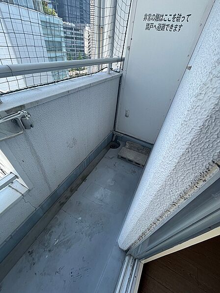 都市の眺望が広がるバルコニー。万が一の際には隣戸へ避難できる安心設計です。日々の暮らしに開放感と安全をお届けします。