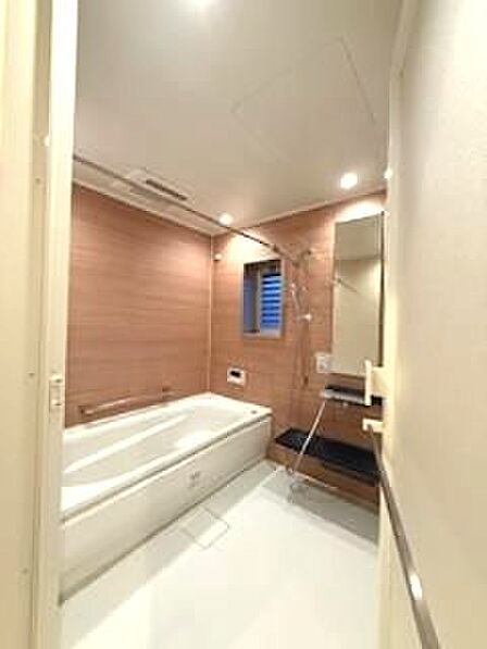 木目調のアクセントパネルが落ち着いた空間を演出する浴室です。一日の疲れを癒すバスタイムをお過ごしください。窓付きで換気もスムーズです。