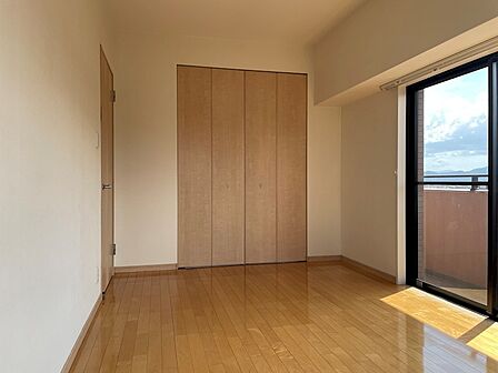 明るい陽射しが差し込む居室は、収納も備え、快適なプライベート空間を演出します。フローリングの温もりと開放的な窓が魅力です。