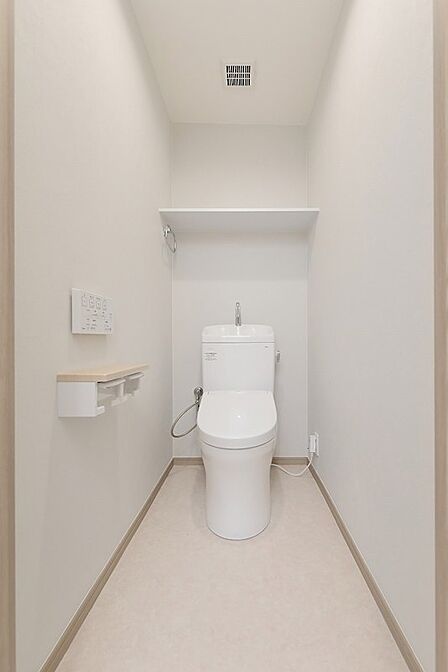 清潔感あふれるシンプルなトイレ空間。上部の棚は、収納や飾り付けにも活用できます。日々を快適に過ごせる工夫が詰まっています。