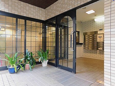 落ち着いたベージュのタイルとグリーンが調和し、住まいの顔であるエントランスに安らぎをもたらします。