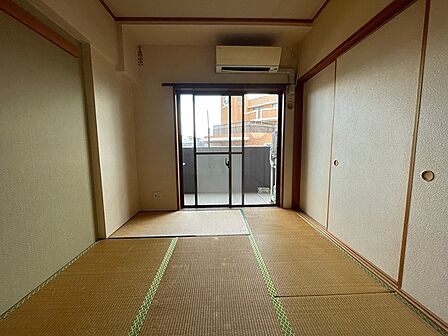 バルコニーに面した和室は、陽光が差し込む開放的な空間。エアコン付きで快適に過ごせます。収納も充実しており、居住空間を有効活用できます。