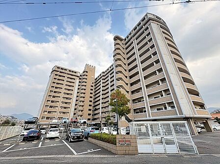 開放感のある空と調和する、堂々たる外観のマンション。敷地内には機械式駐車場も完備され、日々の暮らしをサポートします。