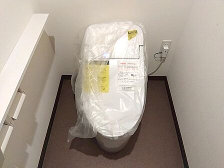 新品のトイレで清潔感あふれる空間。サイドの収納棚がすっきりとした印象を与えます。新生活を快適に始めるための設備が整っています。