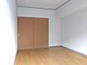 その他：明るいフローリングと白い壁の居室。収納スペースも備え、すっきりと暮らせる空間です。