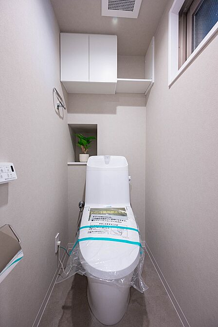 トイレには掃除用具の収納に活用可能な吊戸棚を設置。