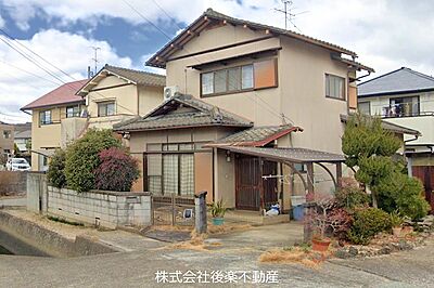外観：木造2階建戸建。屋根付き駐車スペースあり