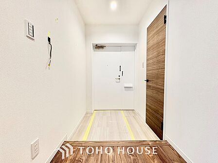 奥行きと幅にゆとりを持たせたフラットな玄関スペース。白を基調とした壁面と上質な木目調ドアがマッチし、毎日の出入りやお客様の迎え入れを温かく心地よく演出します。