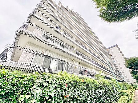 美しく剪定された生垣が敷地沿いに続き、プライバシーと歩行者の安全に配慮された開放的な接道環境。シックなネイビー調タイルが高級感を漂わせ、街並みと調和するモダンな佇まいです。