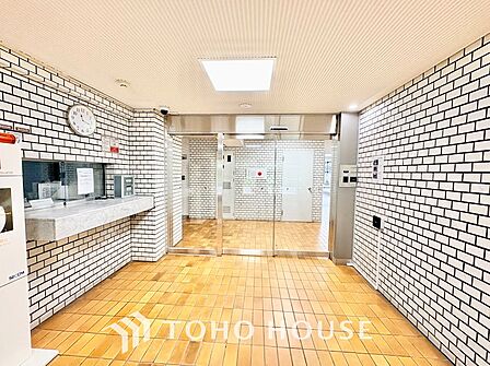 広々とした開放感あふれるホール空間。自動ドアのガラス越しに外の緑を感じられ、オートロックシステムやメールコーナーへのスムーズな動線が居住者の快適で安全な毎日を優しく支えます。