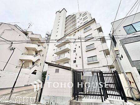 白を基調とした爽やかな外観デザイン。13階建ての存在感あるフォルムで、1階店舗部分や植栽の手入れも行き届いた管理体制の良さが伺えます。