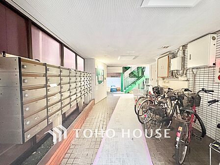 きれいに清掃が行き届いた1階共用廊下。整然と並んだ集合ポストや屋内駐輪エリアなど、管理体制の良さが伺えます。
