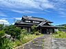 外観：瓦屋根の日本の伝統を感じさせる佇まい。道路から建物までの距離にもゆとりがあり、開放感のある敷地。周囲の自然を感じながら、のんびりとした暮らしを楽しめる住環境です。