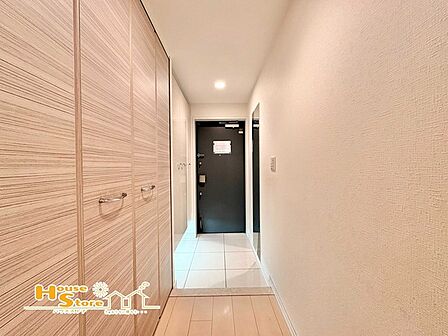 玄関には収納棚が設置され、靴や小物をすっきりと整理できます。棚の上には鍵やインテリア、小さな観葉植物なども置きやすく、実用性と美観を兼ね備えた快適な玄関空間を演出します。