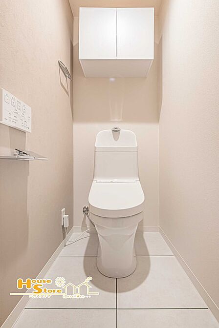清潔感のあるトイレ空間に温水洗浄便座を備え、毎日快適にお使いいただけます。上部には扉付きの収納棚があり、トイレットペーパーなどの用品もすっきり収納でき、生活感を抑えたきれいな空間を保てます。