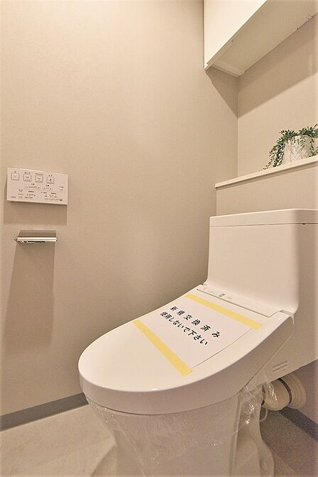 【トイレ】いつでも快適に使える温水洗浄便座付きのトイレ。背面上部には吊戸棚があり、トイレットペーパーや掃除用具をすっきりと収納しておけます。