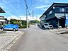 その他：前面道路含む外観写真。幅の広い平坦な舗装公道に面し、車の出し入れもしやすい静かな住宅地です。