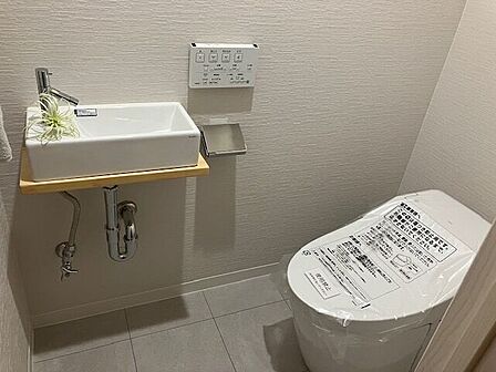 空間を広々と魅せる、清潔感漂うタンクレストイレ。独立した手洗い器を完備し、日常の使いやすさはもちろん、来客時にもスマートに対応できます！