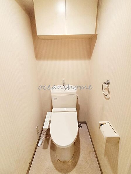 温水洗浄機能付きのトイレで、吊戸棚にトイレ用品をしまえて清潔に使えます♪