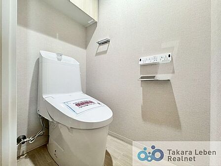 ウォシュレット機能付きのトイレは壁掛けリモコンの上位グレードを採用。便座がスッキリした印象となり、限られた空間を広く見せる効果があります。