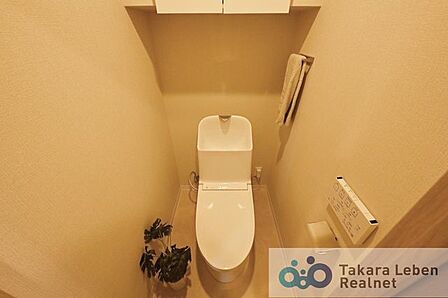 ウォシュレット機能付きのトイレは壁掛けリモコンの上位グレードを採用。便座がスッキリした印象となり、限られた空間を広く見せる効果があります。