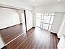 リビング/ダイニング：木目調の床と白い天井が調和する、心地よい開放感のあるリビング。優しい光に包まれながら、くつろぎと美しさが日常に溶け込む空間です。