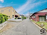 広々とした前面道路に面し、車の出し入れがしやすい現地外観。ゆとりある駐車スペースと開放感のある立地が魅力で、毎日の暮らしに快適さと安心をもたらすマイホームです。