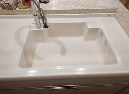 幅広のシンクは洗い物や下ごしらえがしやすく、タイルの立ち上がりが水はねを受け止めます。シングルレバーの水栓で、お湯の温度調整もしやすくなっています。※AIによる家具消し加工を行なっております。