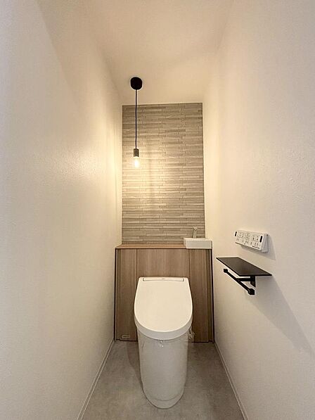 トイレは落ち着いたトーンのアクセントウォールと明るすぎない照明で雰囲気UP。
