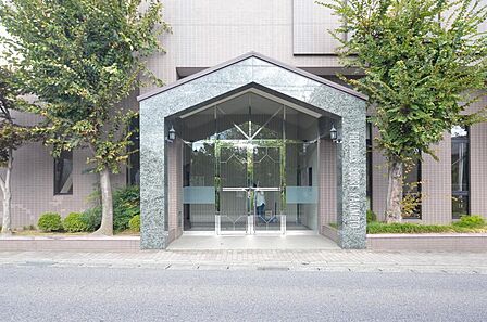 【エントランス】屋根付きで雨の日も安心のエントランス。植栽も丁寧に手入れされています。