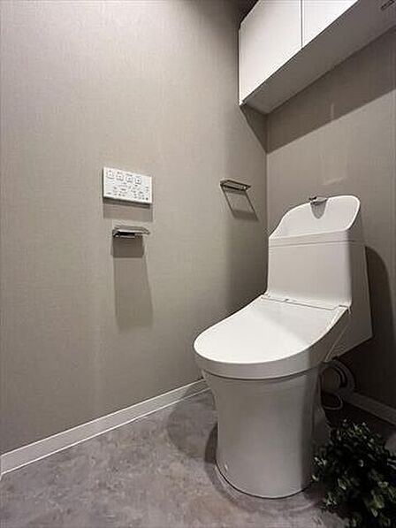 グレージュのアクセントクロスが上質な印象を演出。毎日気持ちよく使えるTOTOトイレです。