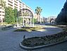周辺：複合滑り台やブランコ、砂場、鉄棒などの遊具があり、子どもたちが元気に遊べます。園内にはヤシの木や季節の花々が植えられ、南国のような雰囲気が漂います。