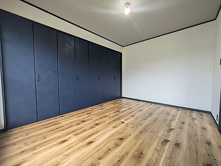 壁一面の収納付き。建具の配色も落ち着いており上質な室内空間となっております