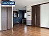 リビング/ダイニング：ダークブラウンの建具と温かみのあるフローリングが調和した、洗練されたデザインの室内です。