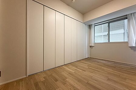 約5帖の洋室2。壁一面の大きなクローゼット付き。寝室としてだけでなく書斎としても利用できるよう、衣類のほか本や資料も仕舞える収納量を確保しました。