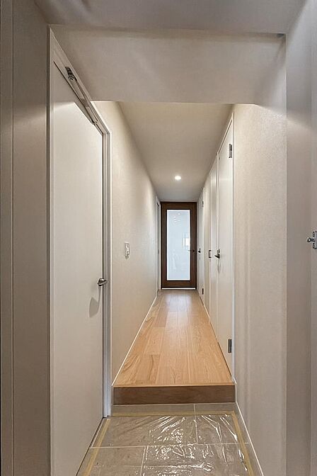 廊下の玄関扉側からLDK側を向いたカット。玄関近くにはトイレがあります。