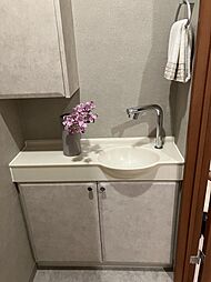 手洗いカウンター下収納や吊戸棚もあるためトイレットペーパーやお掃除用品も全て収納可能です。（同タイプモデルルーム撮影）