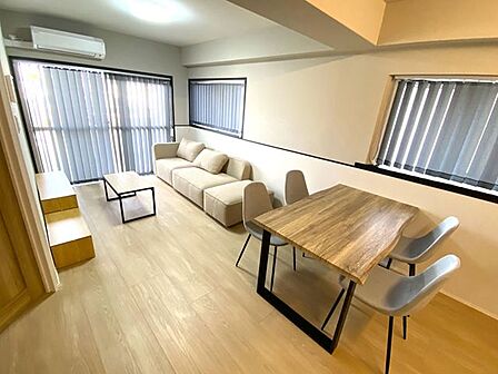 【LDK】各居室へリビングを通る動線で家族の気配を感じられるLDK。バイカラーのカウンターが空間を引き締め、角住戸の出窓から光が入る明るく上質なリビングです。
