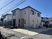 角地に位置し、開放感のある外観が印象的な2階建て住宅。駐車スペースをしっかり確保し、来客時も安心です。シンプルで落ち着いたデザインは周辺の街並みにも調和。日当たりや通風にも配慮された住まいです。