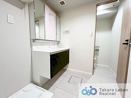 洗面台の横には、防水パン付きの洗濯機置き場があり、家事動線に配慮した配置になっています。