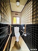 立ち座りの動作をサポートする手すりが設置されたトイレです。ご年配の方やお体の不自由な方も安心して利用できる設計で、安全性に配慮した空間です。